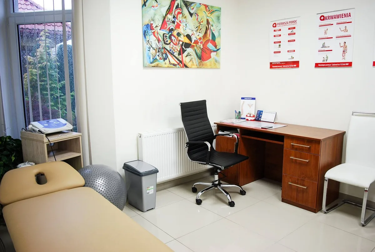 Gabinet fizjoterapii AKU-REH w Brzesku, stół terapeutyczny, biurko i aparat do fizykoterapii